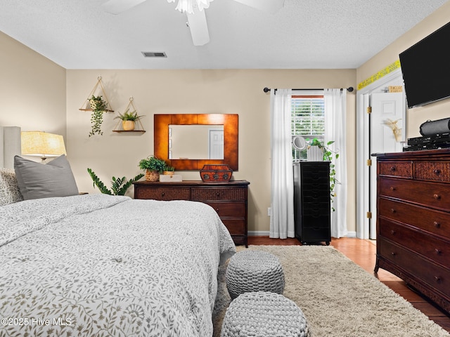 433 Dion Dr, Hubert, NC 28539 - bedroom featuring a textured ceiling, ceiling fan, wood finished floors, and visible vents