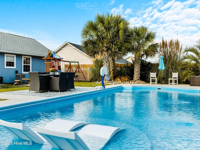 433 Dion Dr, Hubert, NC 28539 - view of swimming pool featuring fence, a fenced in pool, cooling unit, a playground, and a patio