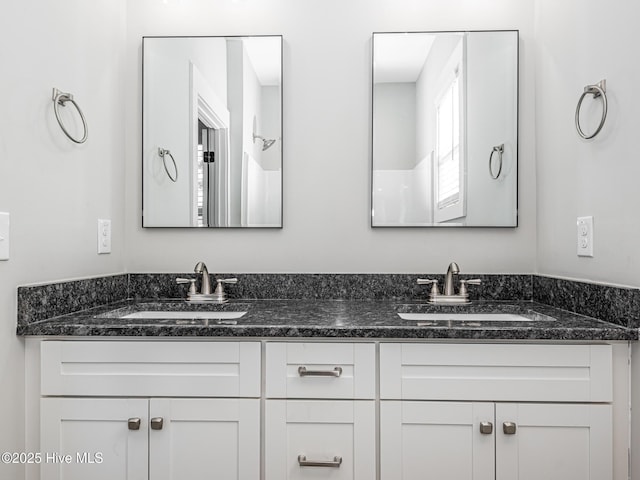 bathroom featuring a sink and double vanity