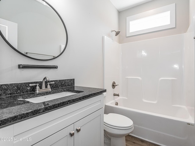 bathroom featuring shower / bathing tub combination, wood finished floors, toilet, and vanity