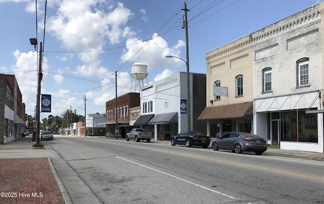 view of road with curbs, sidewalks, and street lights