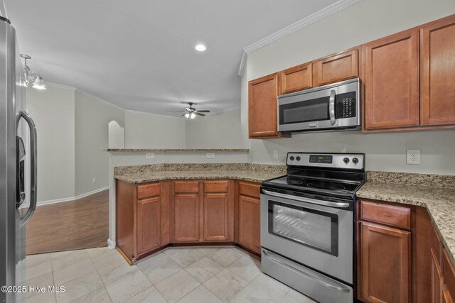 307 Cedar Island Trl, Holly Ridge, NC 28445 - kitchen featuring brown cabinets, ornamental molding, ceiling fan, and stainless steel appliances