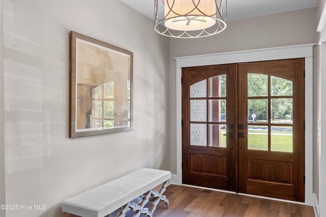 2592 St James Dr SE, Southport, NC 28461 - entryway featuring french doors, wood finished floors, and a chandelier