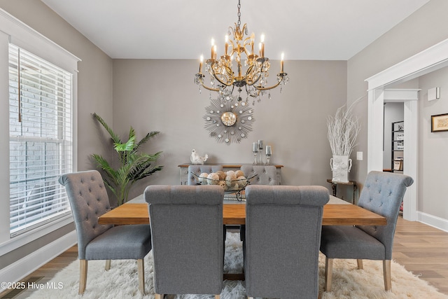 2592 St James Dr SE, Southport, NC 28461 - dining area with a chandelier, wood finished floors, and baseboards