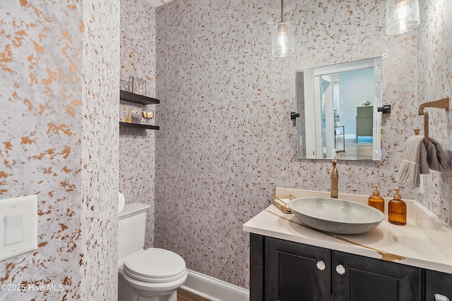 2592 St James Dr SE, Southport, NC 28461 - bathroom featuring vanity, toilet, and wallpapered walls