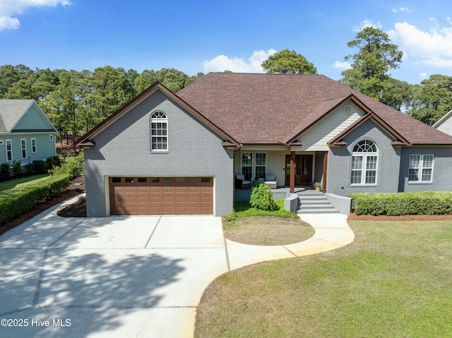2592 St James Dr SE, Southport, NC 28461 - view of front of property featuring concrete driveway, a front yard, brick siding, and a garage