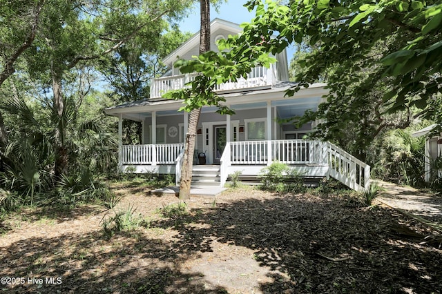 farmhouse inspired home featuring a balcony and covered porch