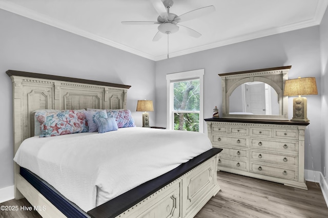 bedroom featuring baseboards, wood finished floors, and crown molding