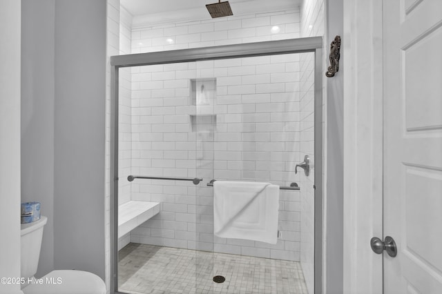 bathroom featuring toilet and a stall shower