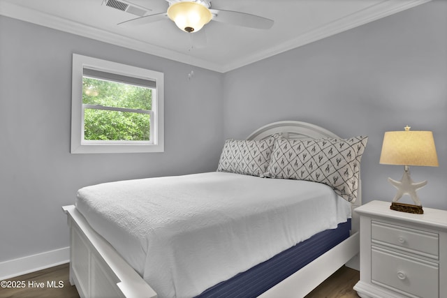 bedroom with dark wood finished floors, baseboards, crown molding, and visible vents