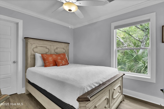 bedroom with ceiling fan, baseboards, crown molding, and wood finished floors