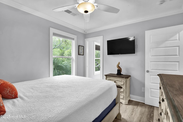 bedroom featuring light wood-style flooring, baseboards, visible vents, ceiling fan, and ornamental molding