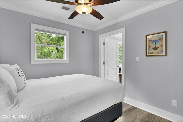 bedroom with baseboards, visible vents, wood finished floors, ceiling fan, and ornamental molding