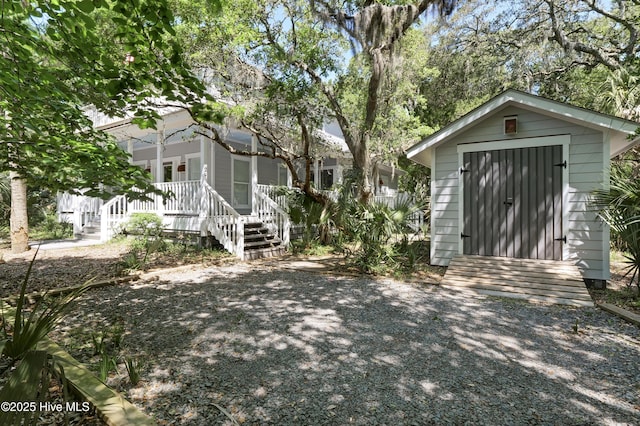 view of shed featuring a porch and stairway