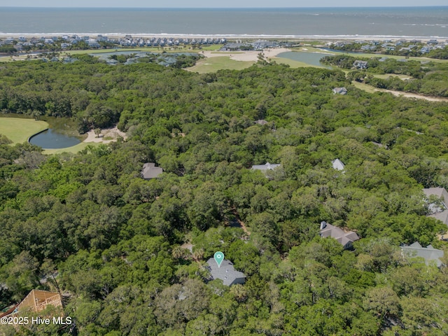 drone / aerial view with a forest view and a water view