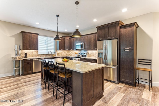 20 Barkley Ln, Pinehurst, NC 28374 - kitchen with stainless steel appliances, dark brown cabinetry, a breakfast bar, and light wood finished floors