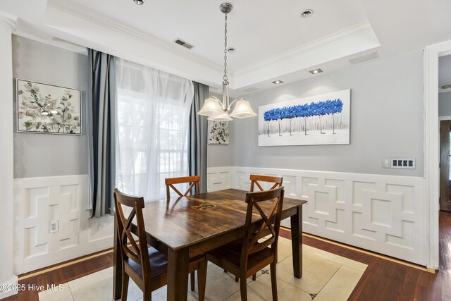 604 Lanvale Hills Cir, Leland, NC 28451 - dining space with a decorative wall, crown molding, visible vents, and a raised ceiling
