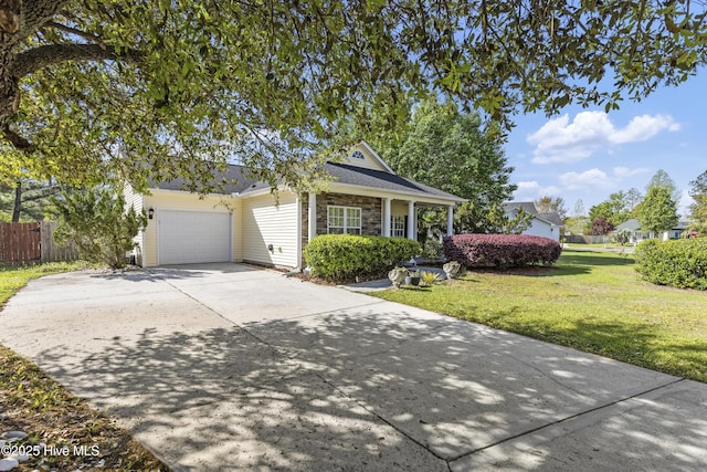 604 Lanvale Hills Cir, Leland, NC 28451 - ranch-style home with fence, concrete driveway, stone siding, a front yard, and a garage