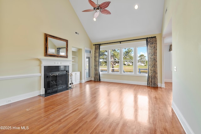 3675 W Medinah Ave, Southport, NC 28461 - unfurnished living room featuring wood finished floors, a fireplace, baseboards, ceiling fan, and high vaulted ceiling