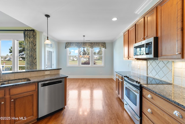 3675 W Medinah Ave, Southport, NC 28461 - kitchen with a sink, brown cabinetry, stainless steel appliances, light wood-type flooring, and tasteful backsplash