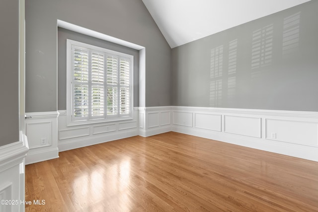 3675 W Medinah Ave, Southport, NC 28461 - spare room with wainscoting, light wood-style flooring, and lofted ceiling