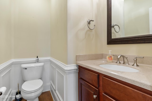 3675 W Medinah Ave, Southport, NC 28461 - bathroom with vanity, wainscoting, a decorative wall, and toilet