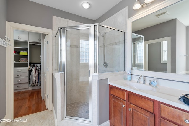 3675 W Medinah Ave, Southport, NC 28461 - full bath featuring a walk in closet, vanity, tile patterned floors, visible vents, and a stall shower
