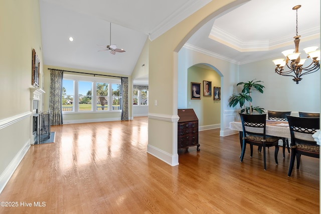 3675 W Medinah Ave, Southport, NC 28461 - dining room with crown molding, arched walkways, baseboards, ceiling fan with notable chandelier, and light wood-style flooring