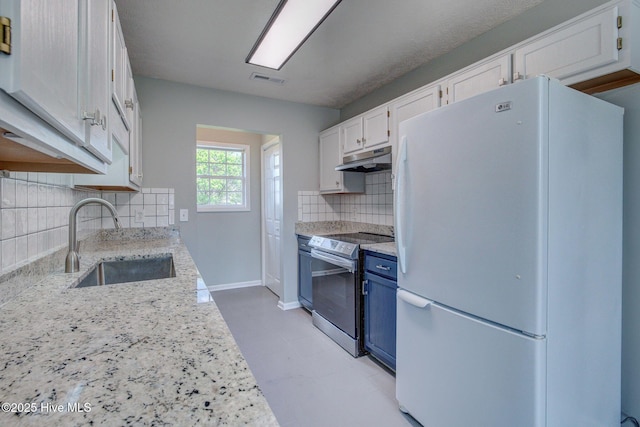 2715 Ashby Dr, Wilmington, NC 28411 - kitchen featuring under cabinet range hood, a sink, freestanding refrigerator, decorative backsplash, and stainless steel electric range oven