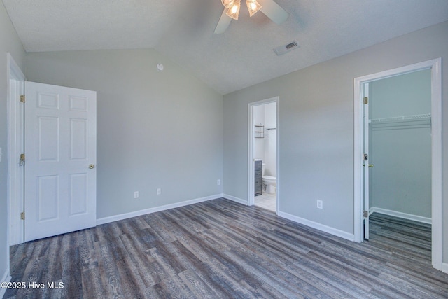 2715 Ashby Dr, Wilmington, NC 28411 - unfurnished bedroom with dark wood-type flooring, lofted ceiling, visible vents, and a walk in closet