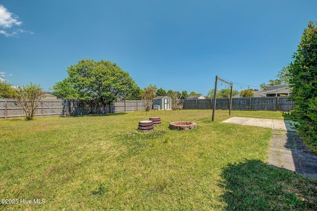 2715 Ashby Dr, Wilmington, NC 28411 - view of yard featuring a fenced backyard, a fire pit, an outdoor structure, a shed, and a patio