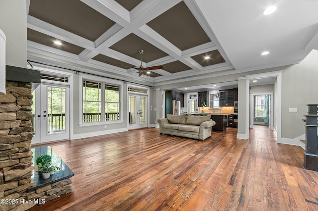 living room with coffered ceiling, dark wood-style flooring, baseboards, and decorative columns