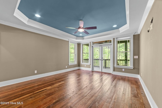 spare room with baseboards, a raised ceiling, french doors, dark wood finished floors, and ceiling fan