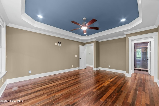 unfurnished room featuring crown molding, a raised ceiling, hardwood / wood-style flooring, and a ceiling fan