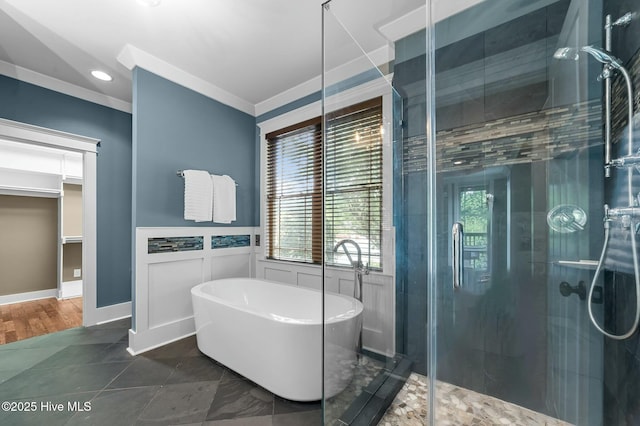 bathroom featuring a shower stall, a freestanding bath, crown molding, and plenty of natural light