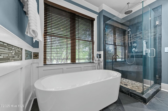 full bathroom featuring a soaking tub, a wainscoted wall, and a stall shower