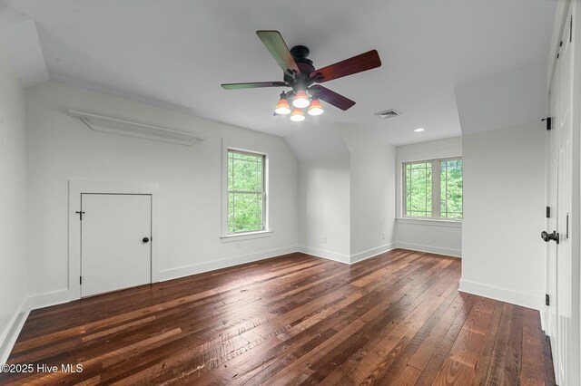 additional living space with vaulted ceiling, visible vents, hardwood / wood-style flooring, and a ceiling fan