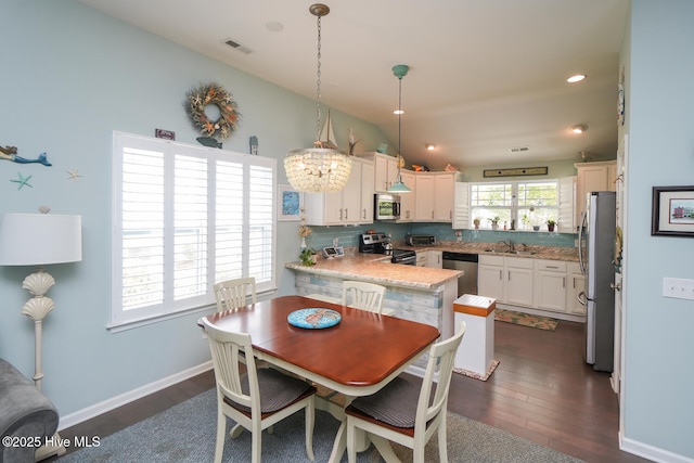 4238 Cherry Laurel Ln SE, Southport, NC 28461 - dining room featuring dark wood-style flooring, a chandelier, lofted ceiling, and recessed lighting