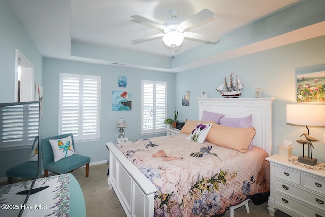 4238 Cherry Laurel Ln SE, Southport, NC 28461 - bedroom featuring a tray ceiling, light carpet, and ceiling fan