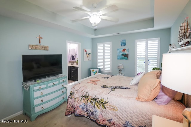 4238 Cherry Laurel Ln SE, Southport, NC 28461 - bedroom featuring a tray ceiling, carpet flooring, ensuite bathroom, and ceiling fan