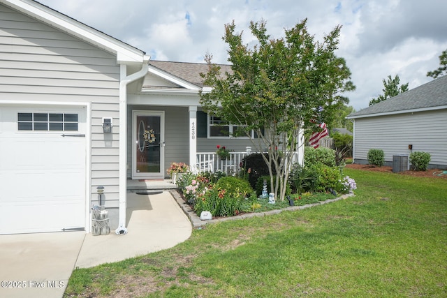 4238 Cherry Laurel Ln SE, Southport, NC 28461 - entrance to property with a garage, covered porch, a lawn, and roof with shingles