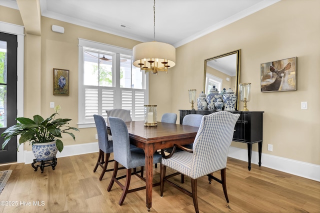 3722 White Cliffs Dr, Castle Hayne, NC 28429 - dining space with plenty of natural light, light wood finished floors, baseboards, a chandelier, and crown molding