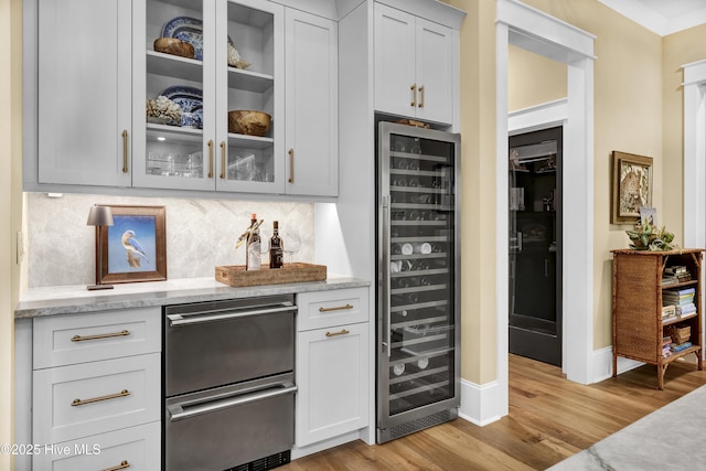 3722 White Cliffs Dr, Castle Hayne, NC 28429 - indoor bar with beverage cooler, light wood finished floors, backsplash, stainless steel dishwasher, and baseboards