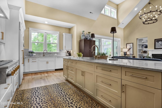 3722 White Cliffs Dr, Castle Hayne, NC 28429 - kitchen with open floor plan, a towering ceiling, a chandelier, a sink, and light stone countertops