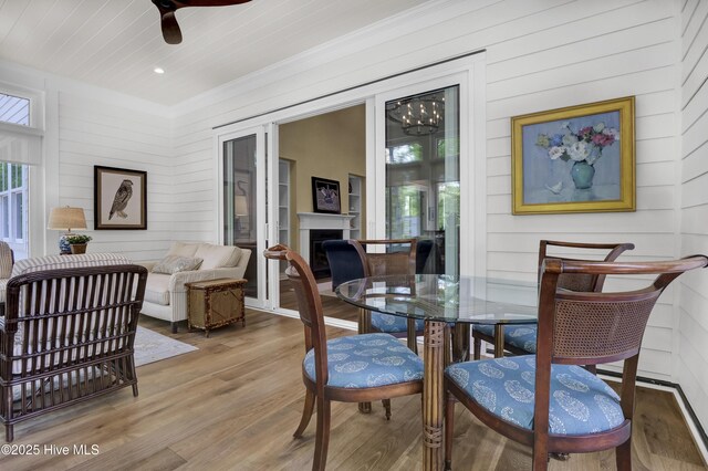 3722 White Cliffs Dr, Castle Hayne, NC 28429 - dining area featuring wood finished floors, a fireplace, ceiling fan, crown molding, and wooden walls
