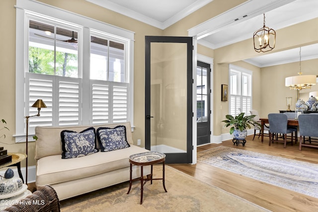 3722 White Cliffs Dr, Castle Hayne, NC 28429 - living area with healthy amount of natural light, a chandelier, wood finished floors, baseboards, and ornamental molding