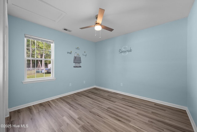 empty room featuring visible vents, baseboards, wood finished floors, and ceiling fan