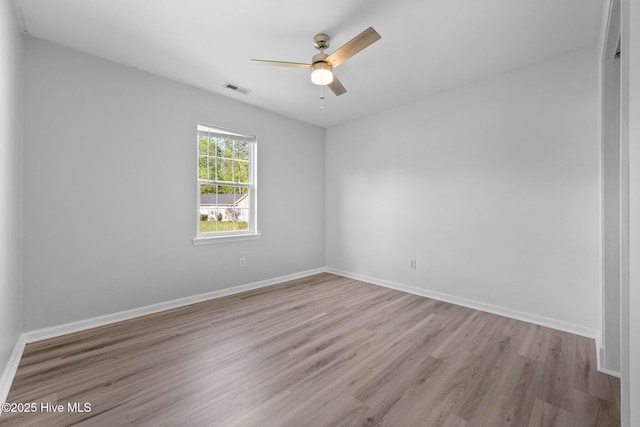 unfurnished room featuring baseboards, visible vents, light wood-style floors, and ceiling fan