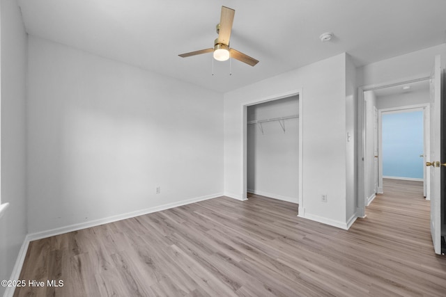 unfurnished bedroom featuring a ceiling fan, baseboards, a closet, and light wood-type flooring