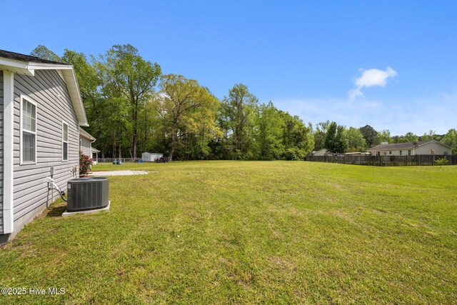 view of yard featuring fence and central air condition unit